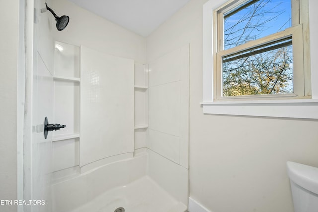 bathroom featuring a shower and toilet