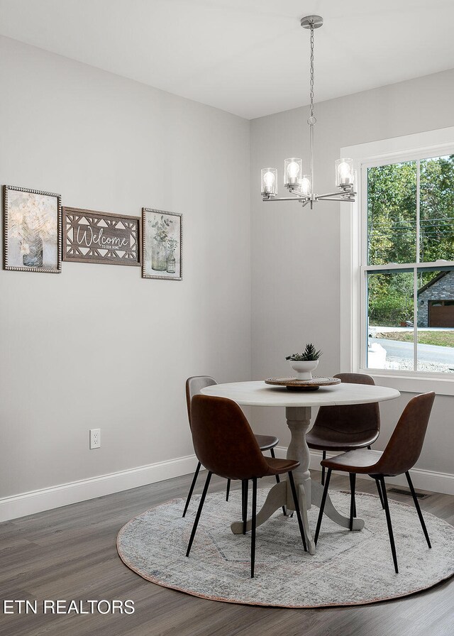 dining room featuring hardwood / wood-style floors and an inviting chandelier