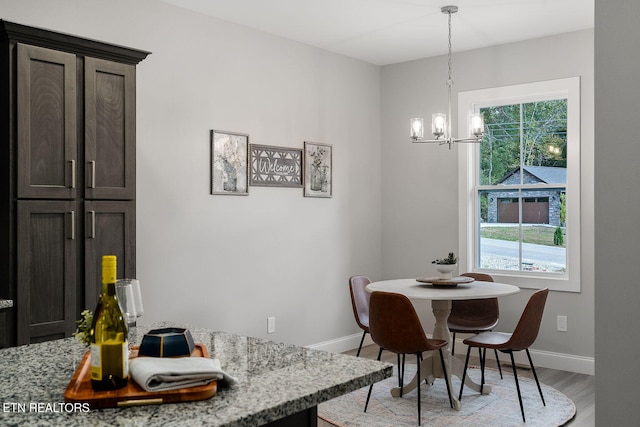 dining area with a notable chandelier and light wood-type flooring