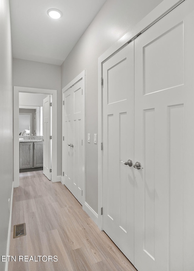 hallway with light hardwood / wood-style flooring