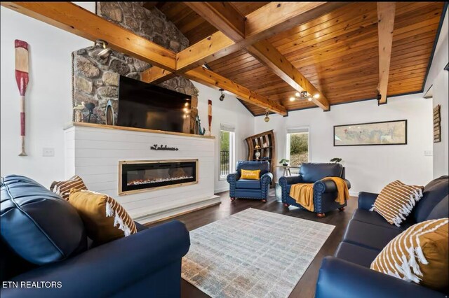 living room with lofted ceiling with beams, dark hardwood / wood-style floors, a stone fireplace, and wood ceiling