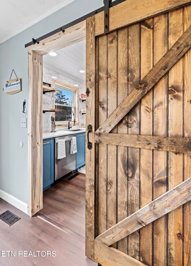 staircase with hardwood / wood-style floors, a barn door, and sink