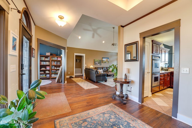 corridor featuring light hardwood / wood-style floors and lofted ceiling