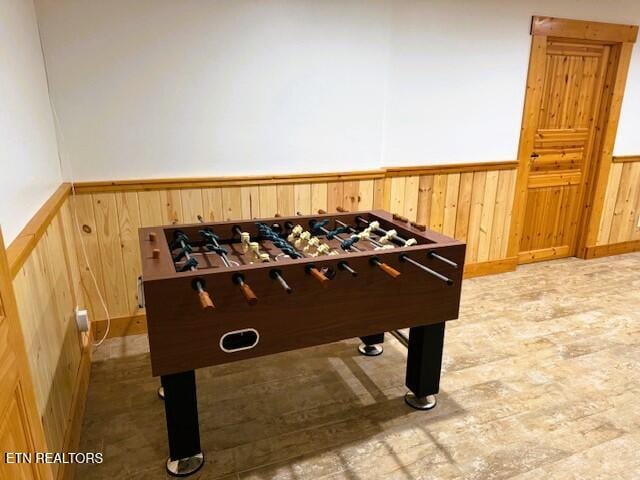 recreation room featuring wood walls