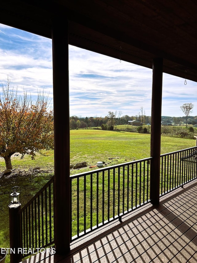 wooden deck featuring a yard and a rural view