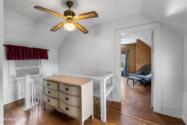 additional living space with lofted ceiling, dark wood finished floors, and a textured ceiling