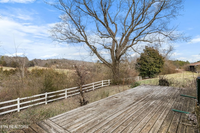 deck featuring fence and a rural view