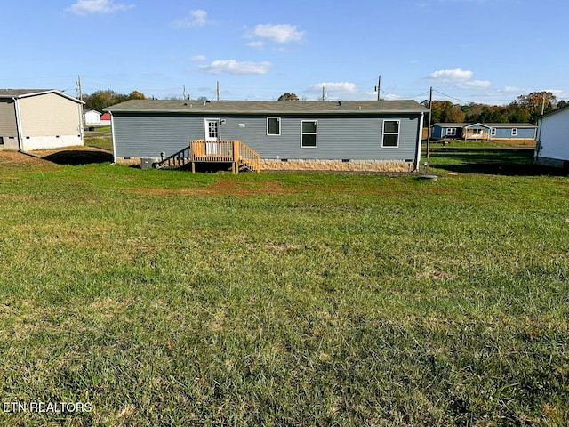 rear view of house with a lawn and a wooden deck