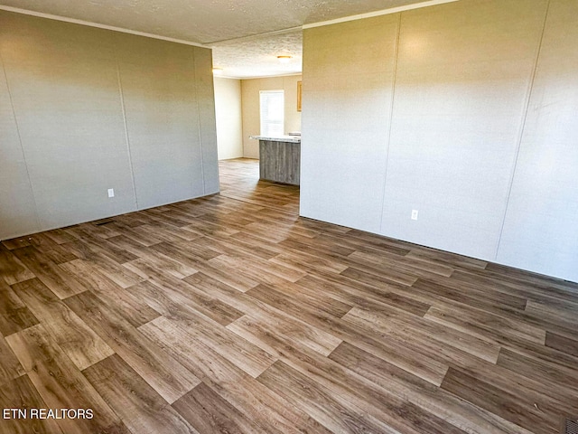 empty room with wood-type flooring and a textured ceiling