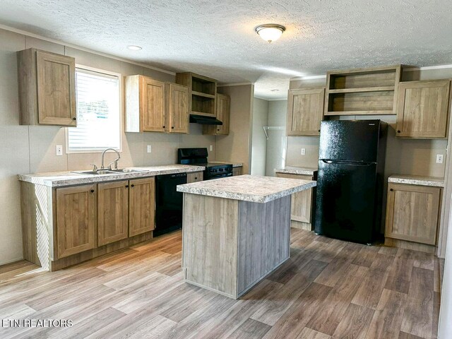 kitchen with black appliances, sink, light hardwood / wood-style flooring, a textured ceiling, and a kitchen island