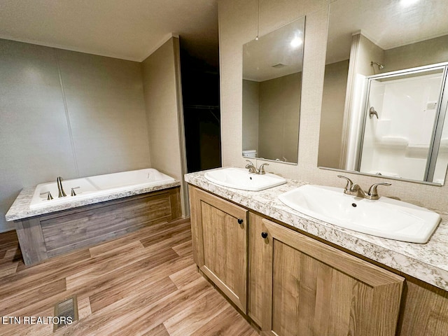 bathroom featuring hardwood / wood-style flooring, vanity, and independent shower and bath