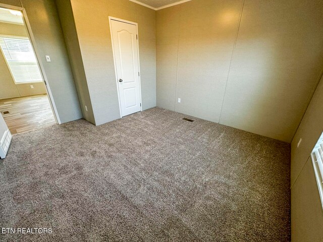 unfurnished bedroom featuring carpet and crown molding