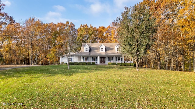 new england style home with a porch and a front lawn