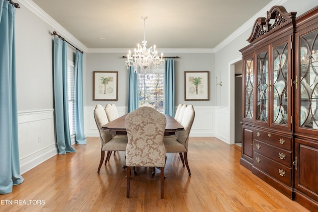 dining room featuring a chandelier, light hardwood / wood-style flooring, and crown molding