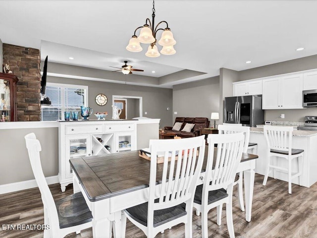 dining room featuring hardwood / wood-style floors and ceiling fan with notable chandelier