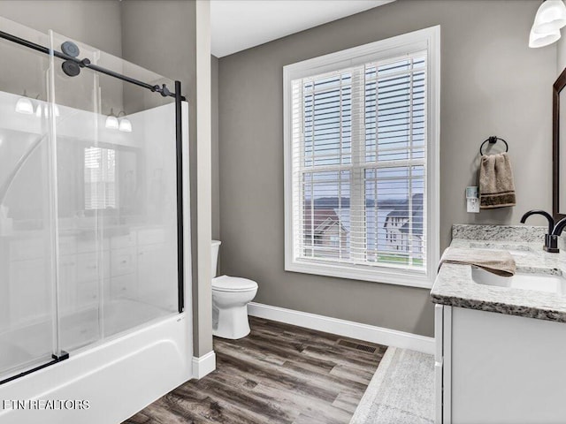 full bathroom featuring enclosed tub / shower combo, plenty of natural light, vanity, and wood-type flooring