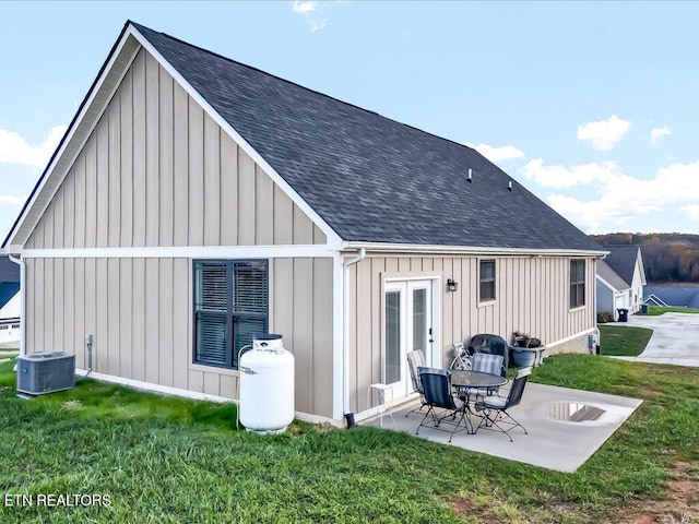 rear view of house with a patio, central AC unit, and a lawn