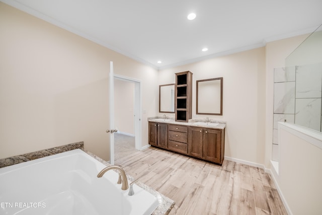 bathroom with vanity, hardwood / wood-style floors, crown molding, and a tub