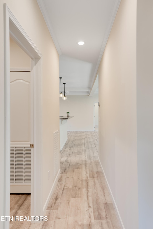 hallway with crown molding and light hardwood / wood-style floors