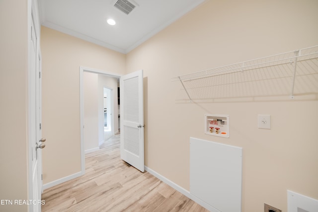 clothes washing area featuring hookup for a washing machine, ornamental molding, electric dryer hookup, and light hardwood / wood-style flooring