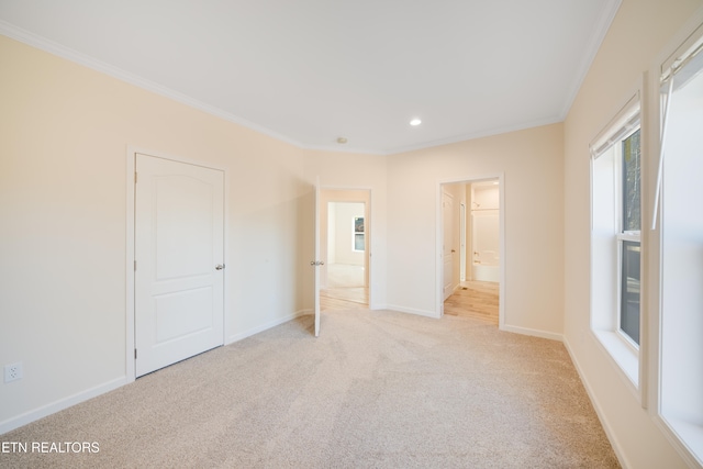 unfurnished bedroom featuring light carpet, ensuite bath, and ornamental molding