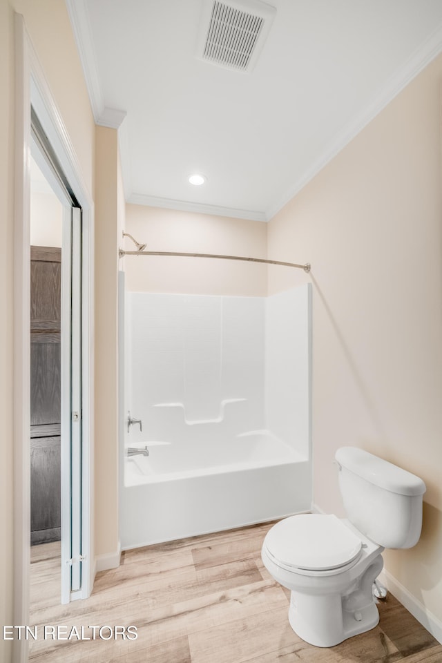 bathroom featuring crown molding, shower / bathtub combination, wood-type flooring, and toilet