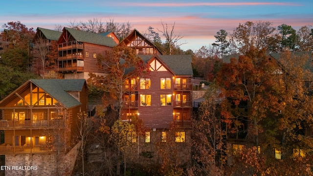 back house at dusk with a balcony