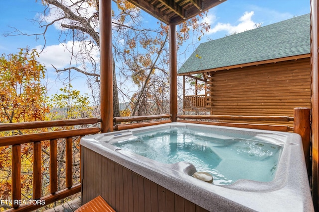 wooden deck featuring a hot tub