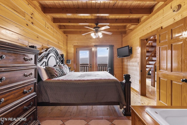1707 High Rock Way, Sevierville, TN 37862 - bedroom with wooden ceiling with exposed beams, wooden walls, light tile patterned floors, and access to outside