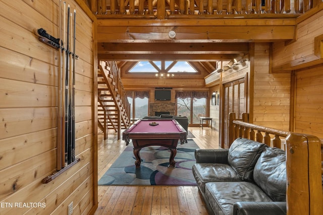 recreation room with beamed ceiling, hardwood / wood-style flooring, wood walls, and pool table