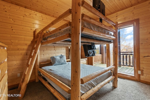 carpeted bedroom featuring wood walls, access to exterior, and wooden ceiling