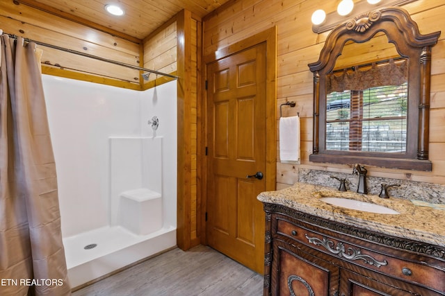 bathroom with hardwood / wood-style floors, vanity, wooden ceiling, wooden walls, and walk in shower