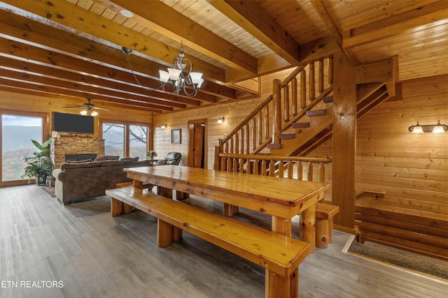 dining space featuring wood walls, a fireplace, wooden ceiling, and hardwood / wood-style flooring