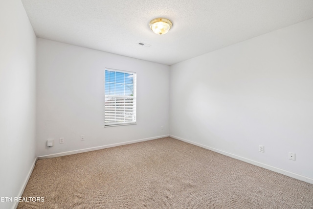 unfurnished room featuring carpet floors and a textured ceiling