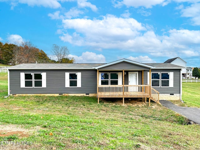 manufactured / mobile home with a front lawn and a wooden deck