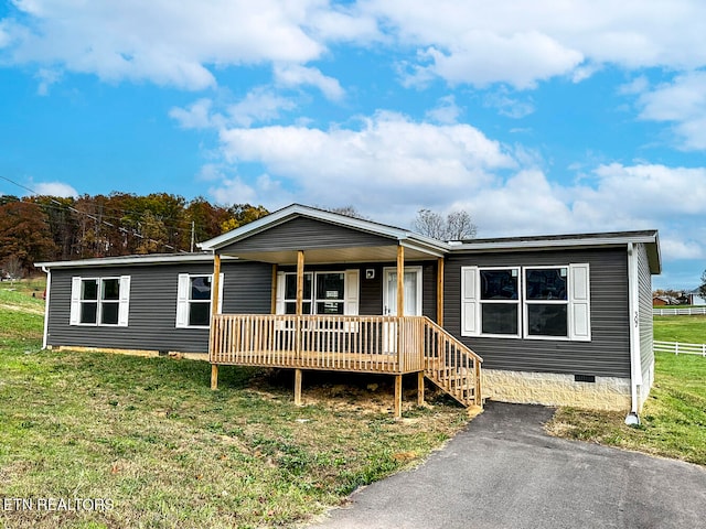 manufactured / mobile home featuring covered porch and a front yard