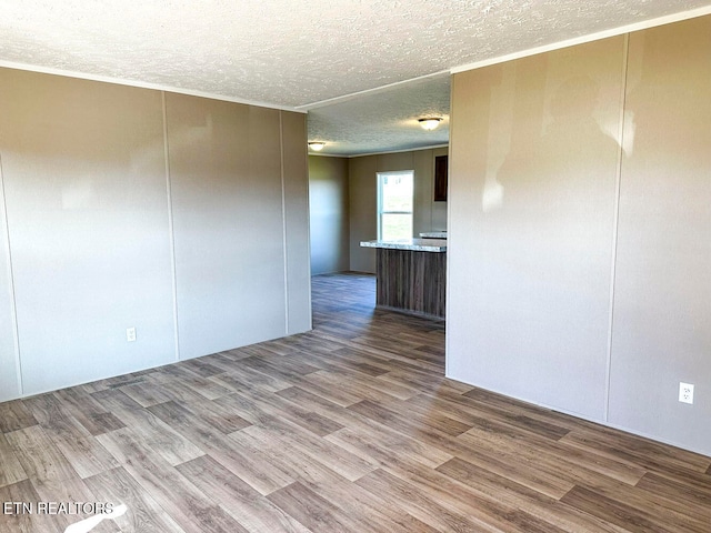 spare room featuring light hardwood / wood-style floors and a textured ceiling