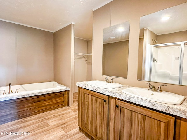 bathroom featuring separate shower and tub, crown molding, vanity, and wood-type flooring