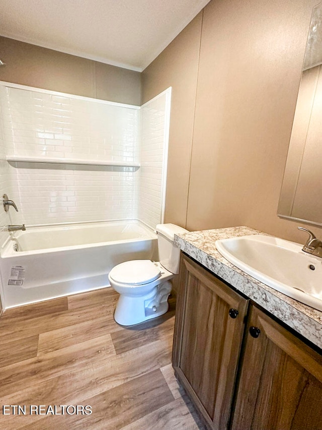 full bathroom featuring vanity, hardwood / wood-style flooring, toilet, and tiled shower / bath combo