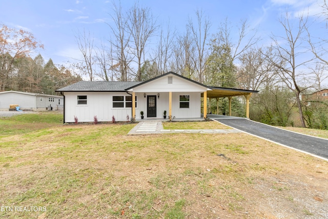 view of front of property featuring a front yard, a carport, and covered porch