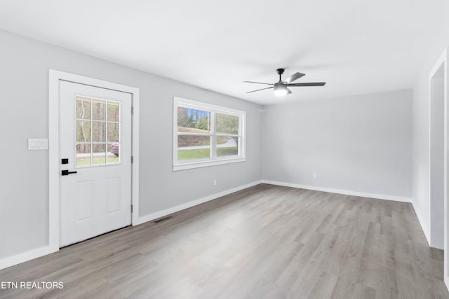 foyer entrance with a wealth of natural light, ceiling fan, and light hardwood / wood-style floors