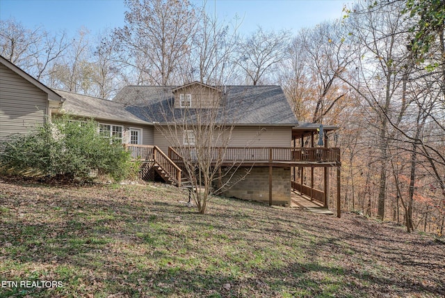 rear view of property featuring a wooden deck