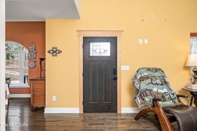 foyer entrance with a textured ceiling and dark hardwood / wood-style floors