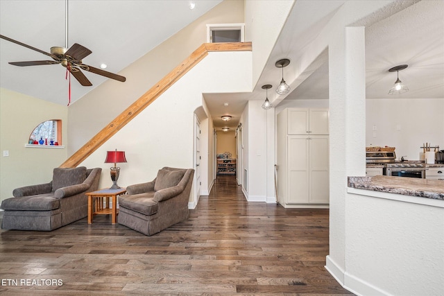 living room featuring dark hardwood / wood-style flooring, high vaulted ceiling, and ceiling fan