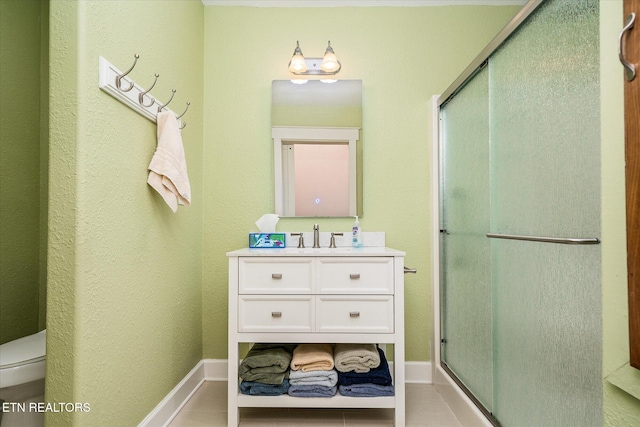 bathroom with tile patterned flooring, vanity, toilet, and a shower with door