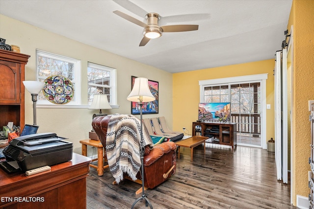 sitting room featuring dark hardwood / wood-style floors, a wealth of natural light, and ceiling fan