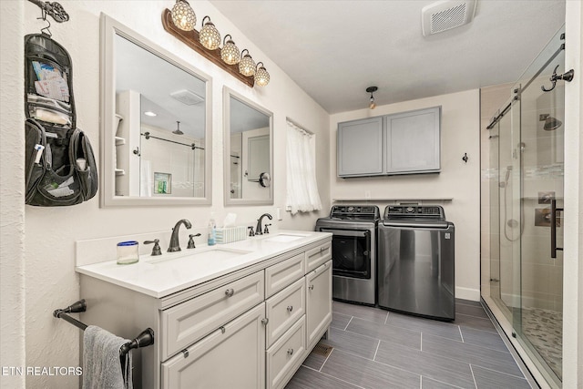 bathroom with vanity, separate washer and dryer, and walk in shower