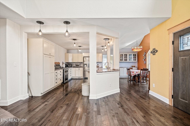 kitchen with white cabinets, stainless steel fridge with ice dispenser, dark wood-type flooring, and hanging light fixtures