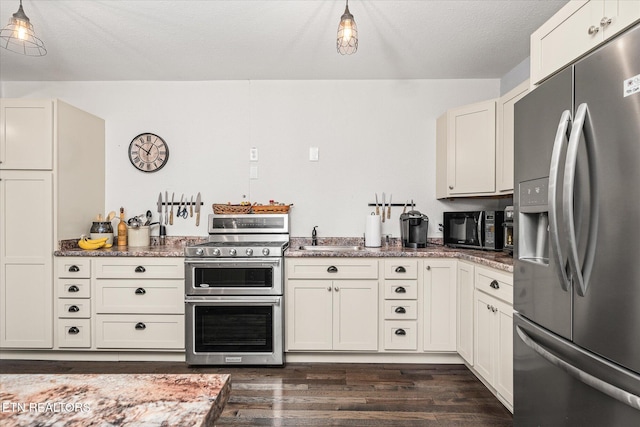 kitchen with white cabinets, sink, dark hardwood / wood-style floors, a textured ceiling, and appliances with stainless steel finishes