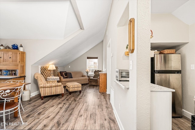 living room with hardwood / wood-style floors and lofted ceiling